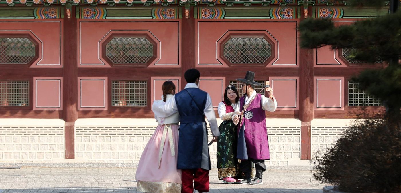 Visitors in hanbok at Gyeongbokgung. Rental hanbok is everywhere around the palaces — and the ask-first rule applies to them too.