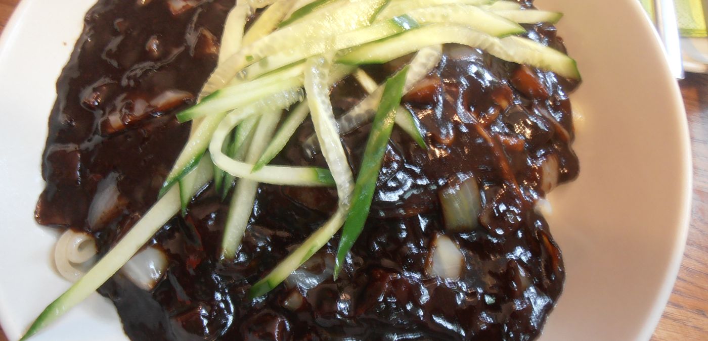 Jjajangmyeon before it is mixed. The sauce sits on top; the noodles underneath are plain.