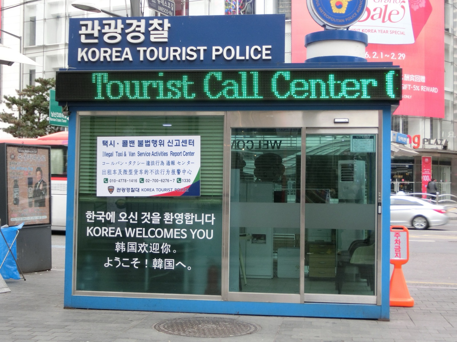 明洞にある青と白の観光警察のブース。「Tourist Call Center」の電光表示と、韓国語・英語・中国語・日本語の歓迎メッセージが見える
