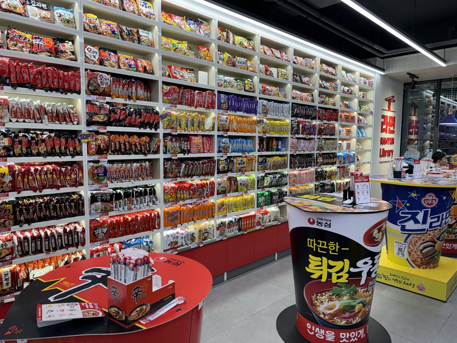 Shelves filled with hundreds of Korean instant noodle packets in a ramyeon-themed convenience store in Hongdae, Seoul