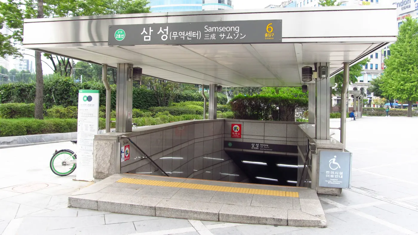 Covered entrance number 6 of Samseong Station on Seoul Subway Line 2, with stairs leading down and trees behind