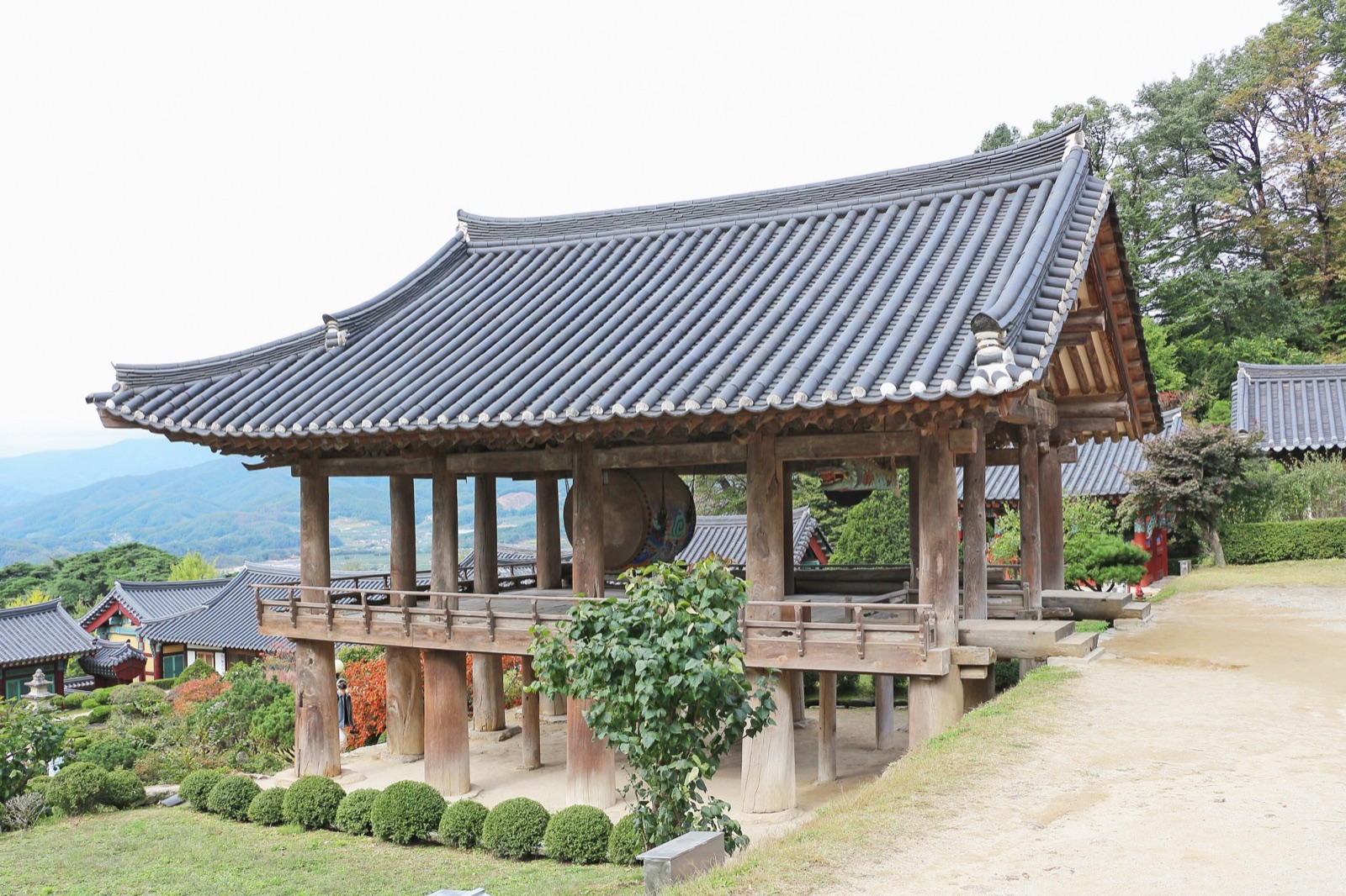 慶尚北道の山寺・浮石寺（プソクサ）の瓦屋根の鐘楼。背後には青い山並みが幾重にも重なっている